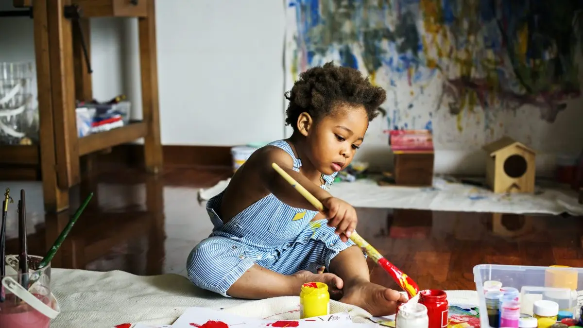 niño pequeño jugando con pintura