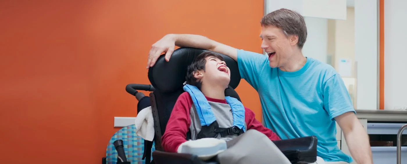 Un niño sonriendo con un familiar durante la rehabilitación con células madre